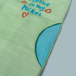 green jumpsuit with Sunshine in my pocket embroided on it