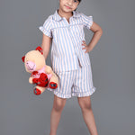A girl wearing Blue striped cotton night dress with shorts and holding a doll