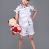 A girl wearing Blue striped cotton night dress with shorts and holding a doll