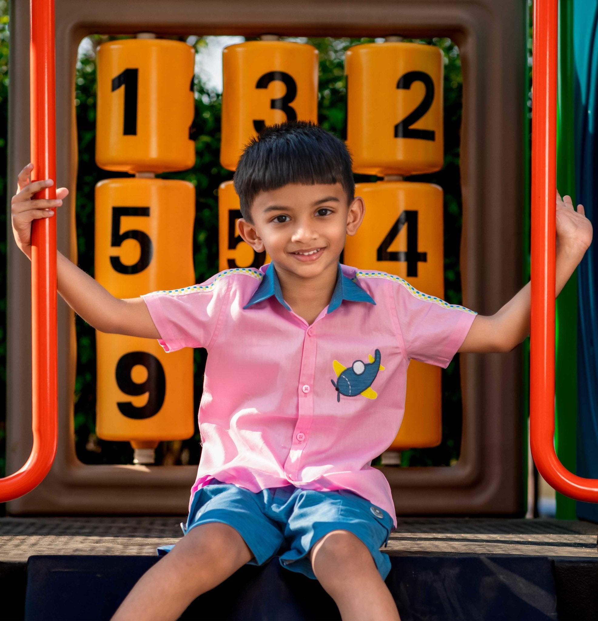 Boy wearing Candy pink Aeroplane shirt & light Denim Shorts