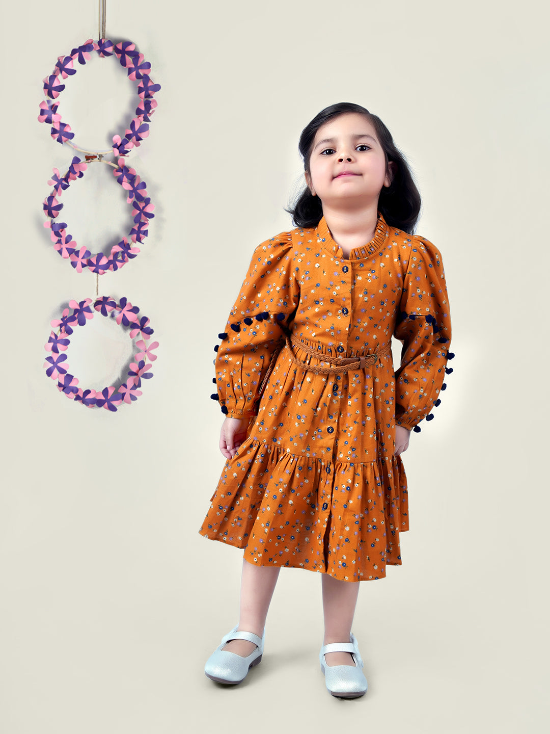 A girl wearing mustard color printed cotton frock with belt