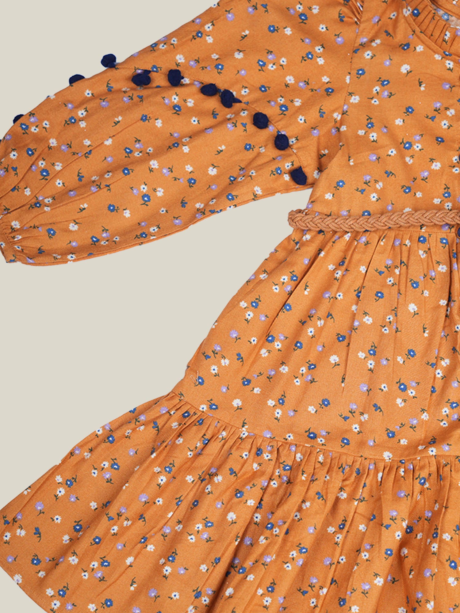 A girl wearing mustard color printed cotton frock with belt